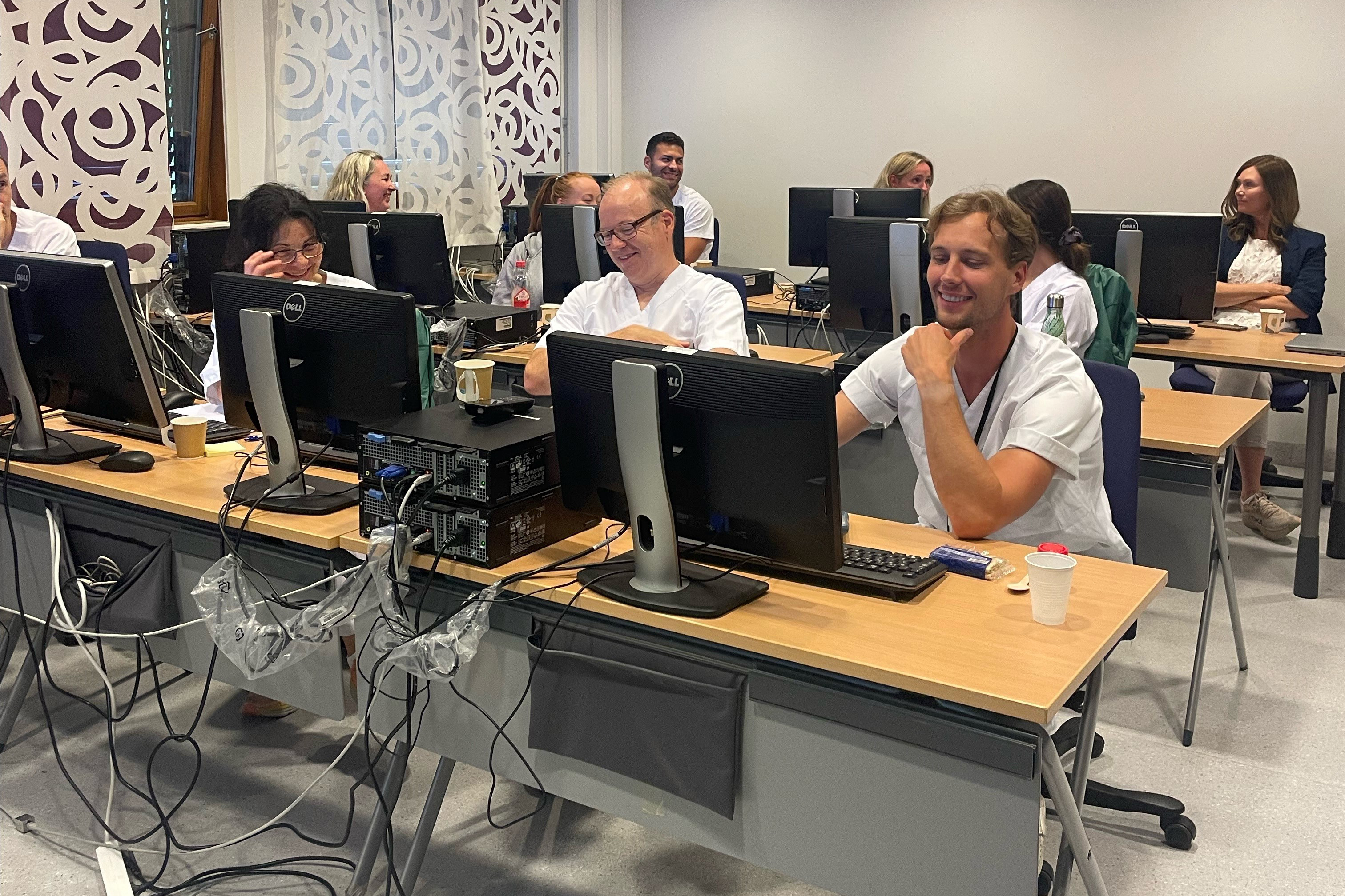 En gruppe mennesker som sitter ved datamaskiner