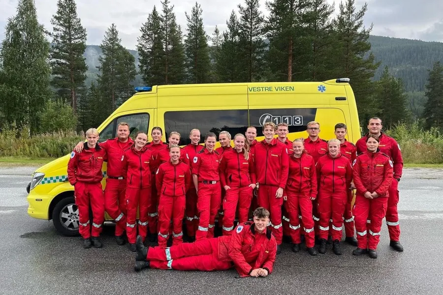 En gruppe mennesker i røde dresser som poserer for et bilde