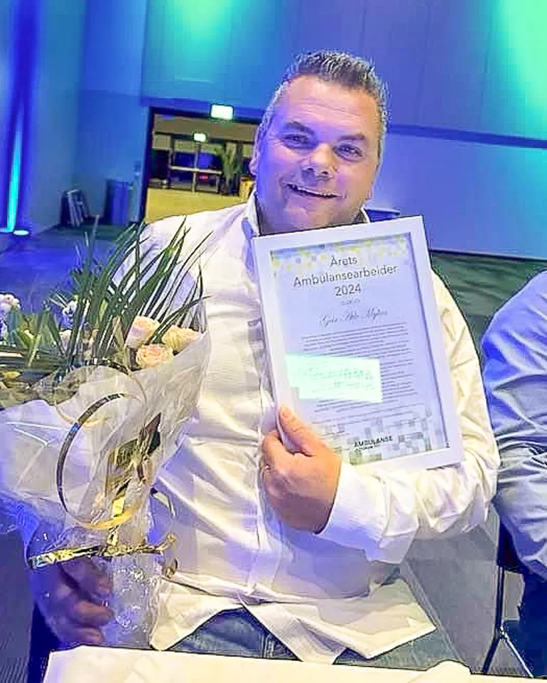 En mann som holder et trofé