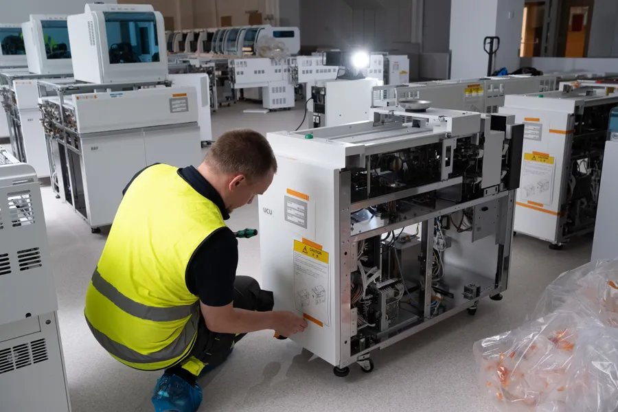 En mann i gul vest som jobber på en fabrikk