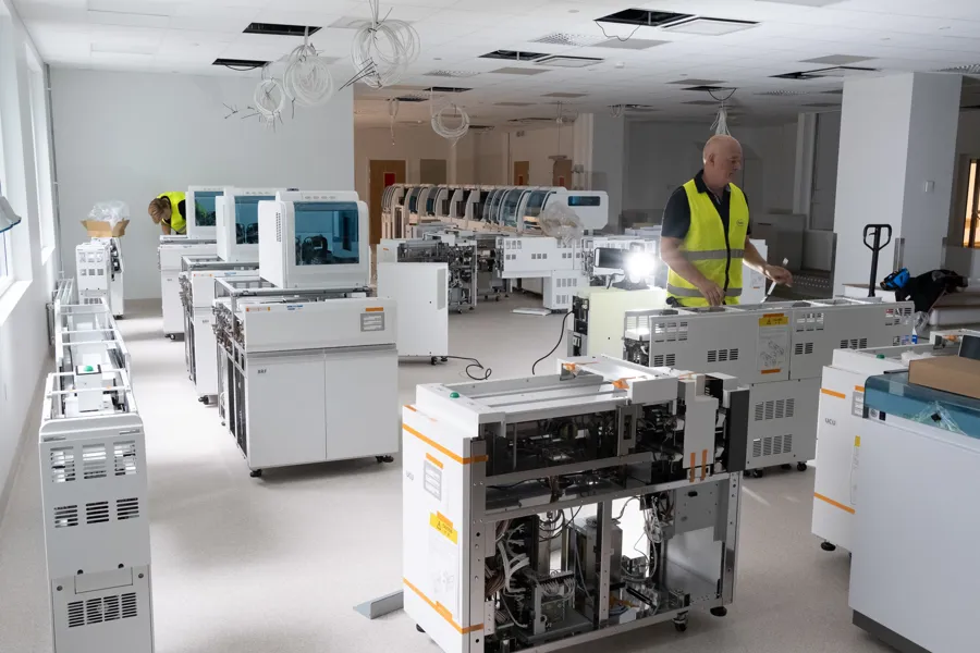 En mann som står i et rom fullt av maskiner