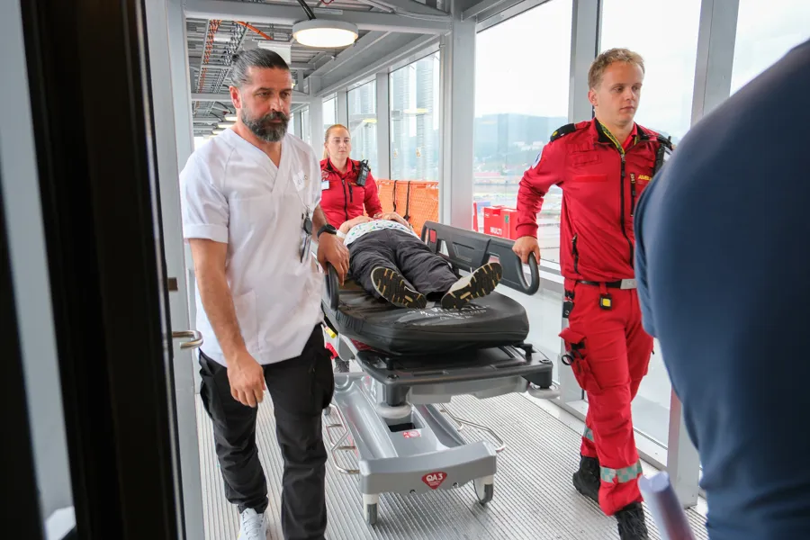 En gruppe menn som står ved siden av en mann i en båre