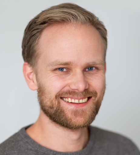 En mann med skjegg som smiler