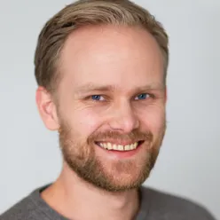En mann med skjegg som smiler