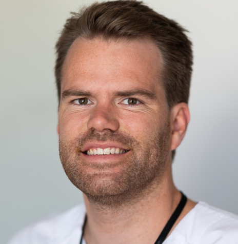 En mann som smiler til kameraet