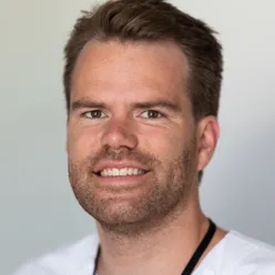En mann som smiler til kameraet