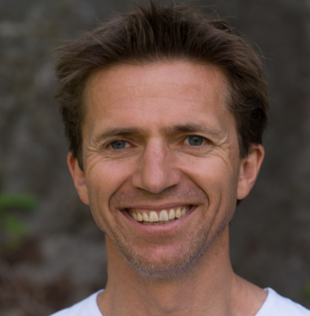 En mann som smiler til kameraet