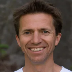 En mann som smiler til kameraet