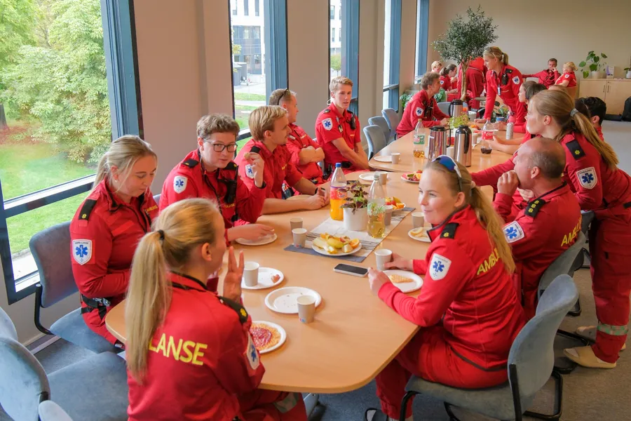 En gruppe mennesker som sitter rundt et bord og spiser mat