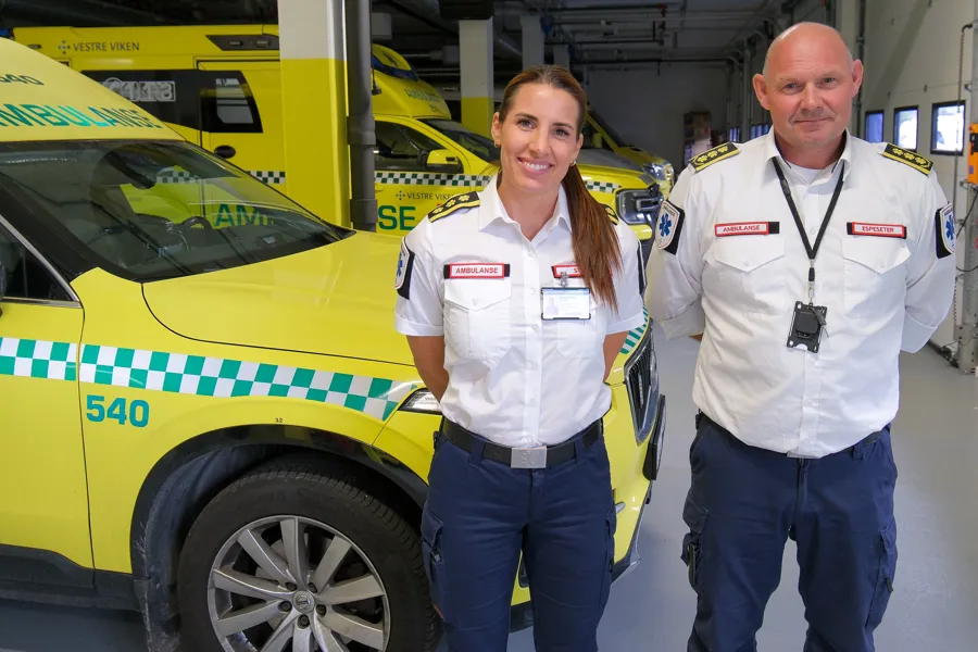 En mann og en kvinne foran en gul lastebil