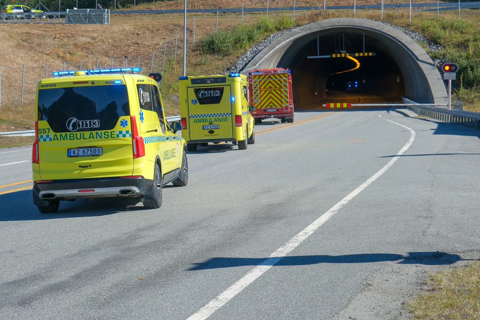 En gruppe gule lastebiler på en vei