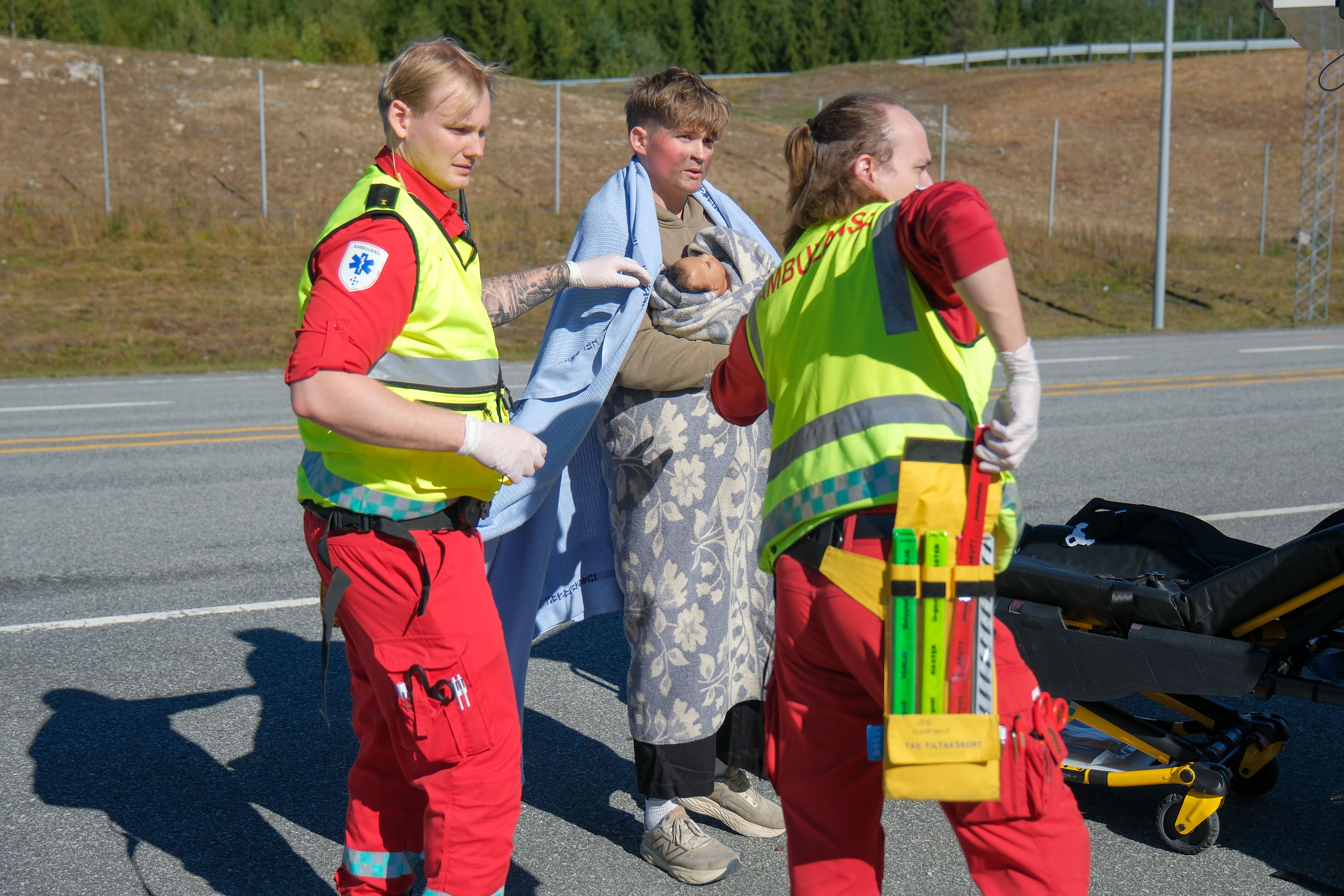 En gruppe mennesker i sikkerhetsvester som står ved siden av en person i dress