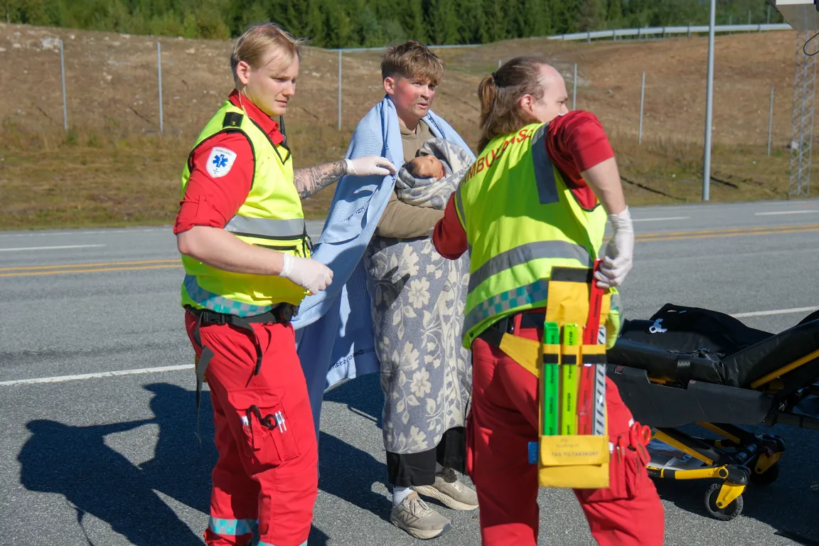 En gruppe mennesker i sikkerhetsvester som står ved siden av en person i dress