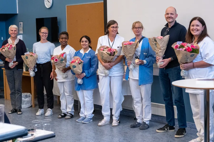 En gruppe mennesker som holder blomster