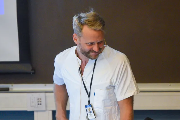 En mann iført hvit skjorte