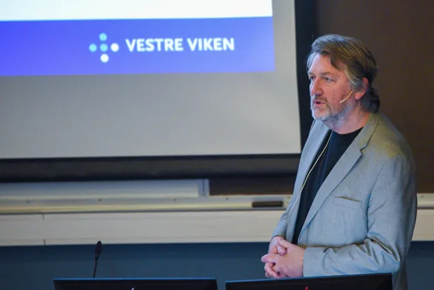 En mann som står foran en skjerm