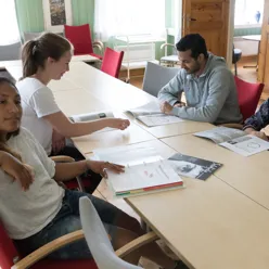 En gruppe mennesker som sitter ved et bord og ser på papirer