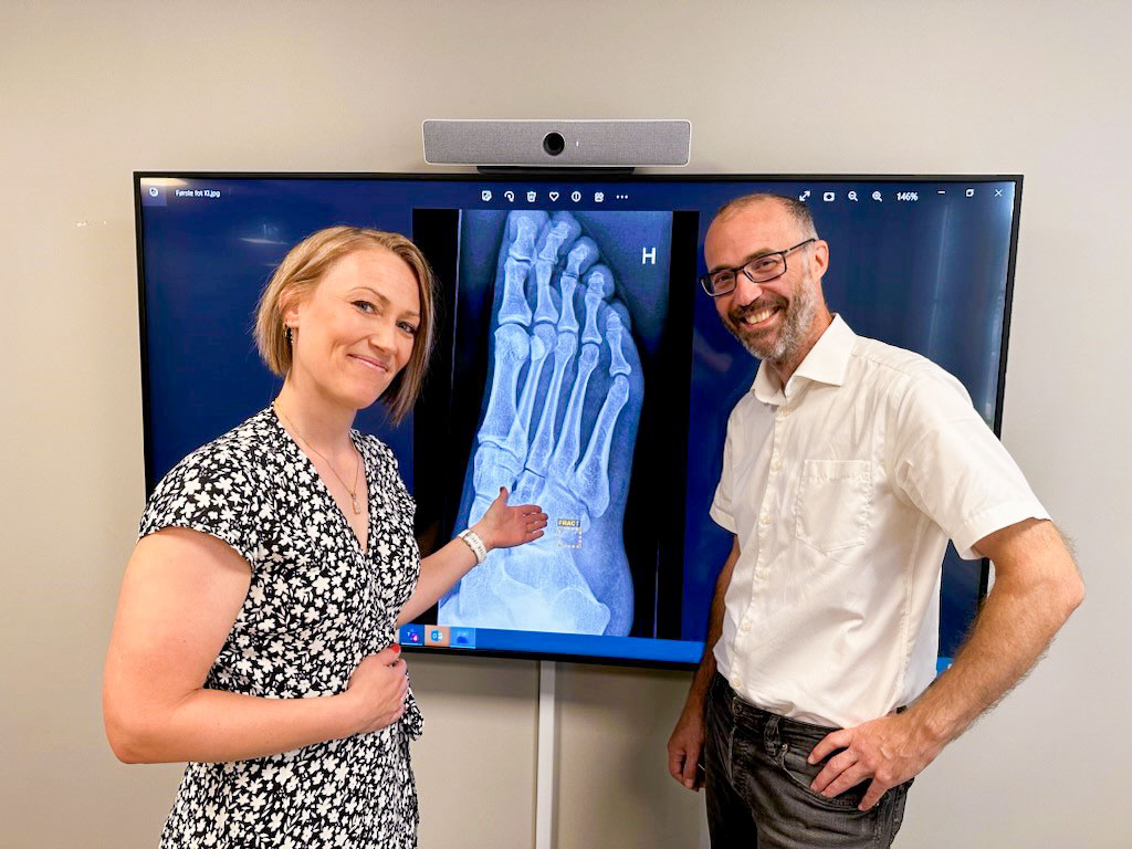 En mann og en kvinne som står foran et fjernsyn