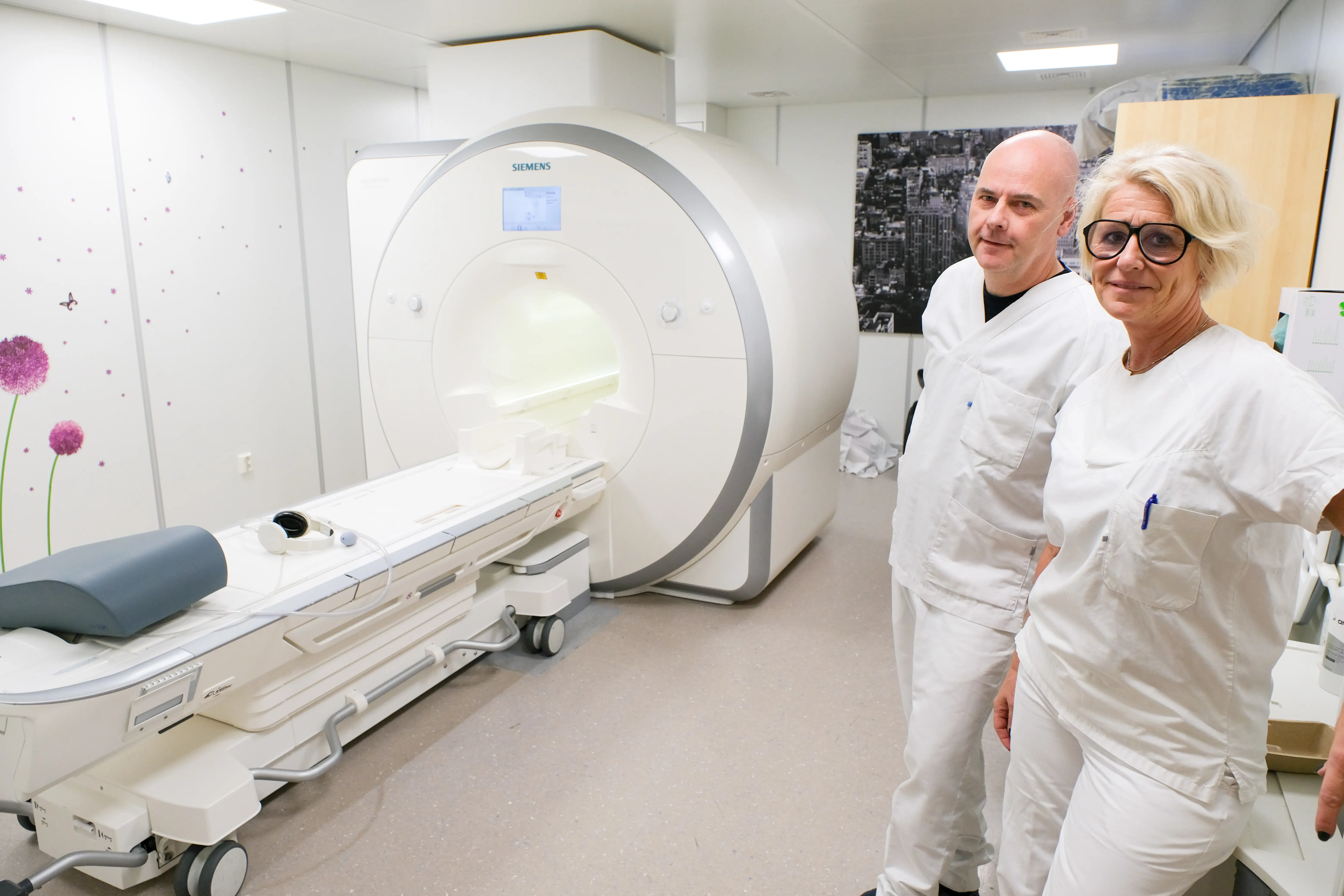 Radiografene Rune Dahlgren og Siv Fjæstad Amundsen ved siden av MR-maskinen på Drammen sykehus