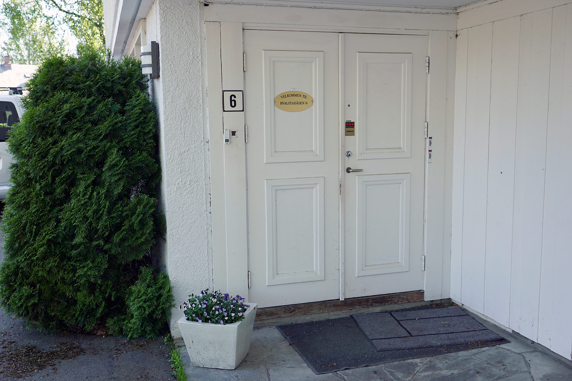 En hvit dør med en planter