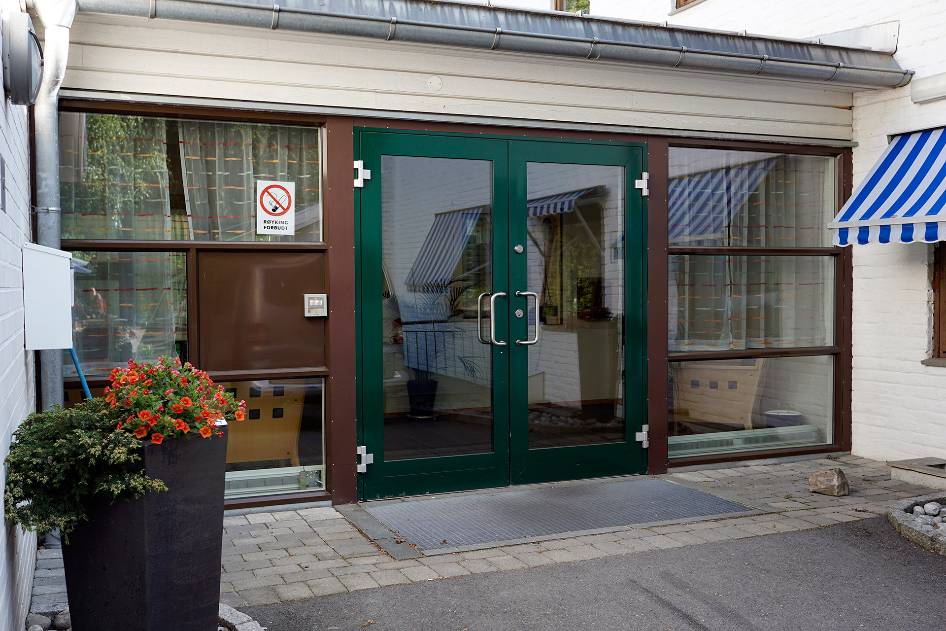 En butikkfront med grønn dør