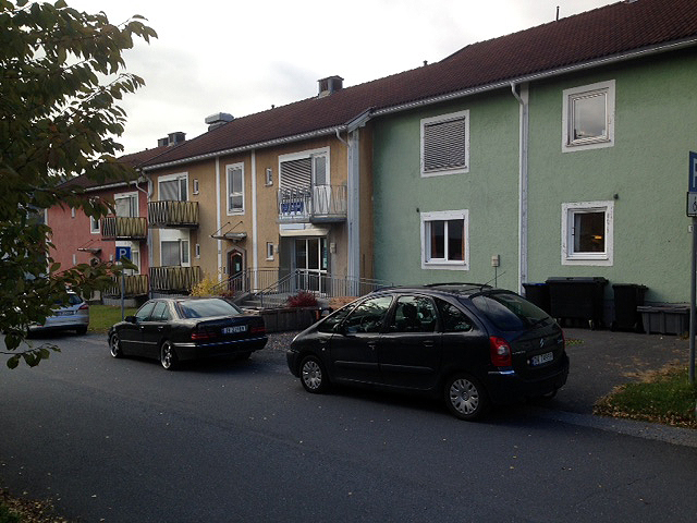 Et par biler parkert foran et hus