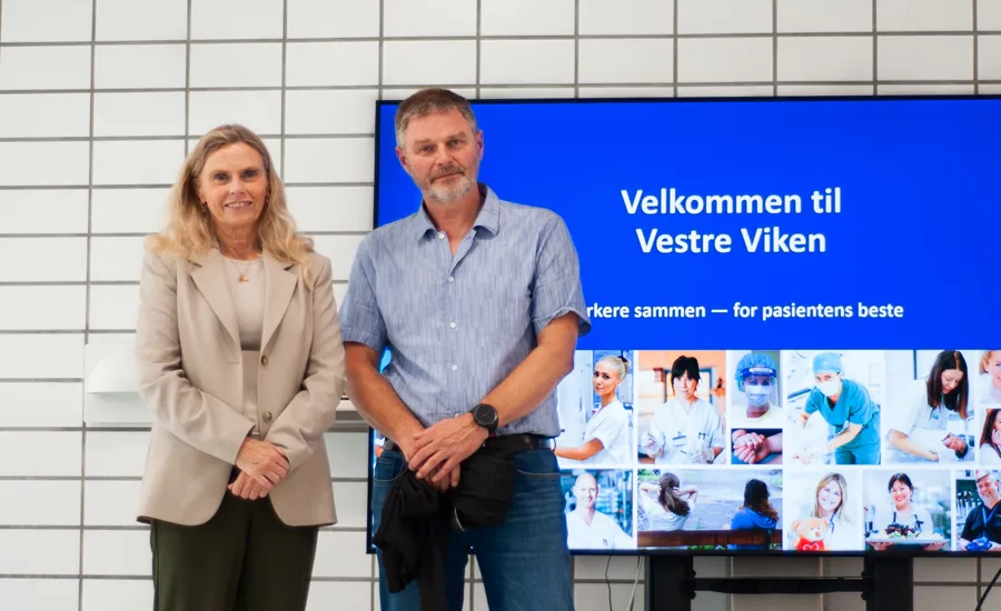 En mann og en kvinne som står foran et skilt