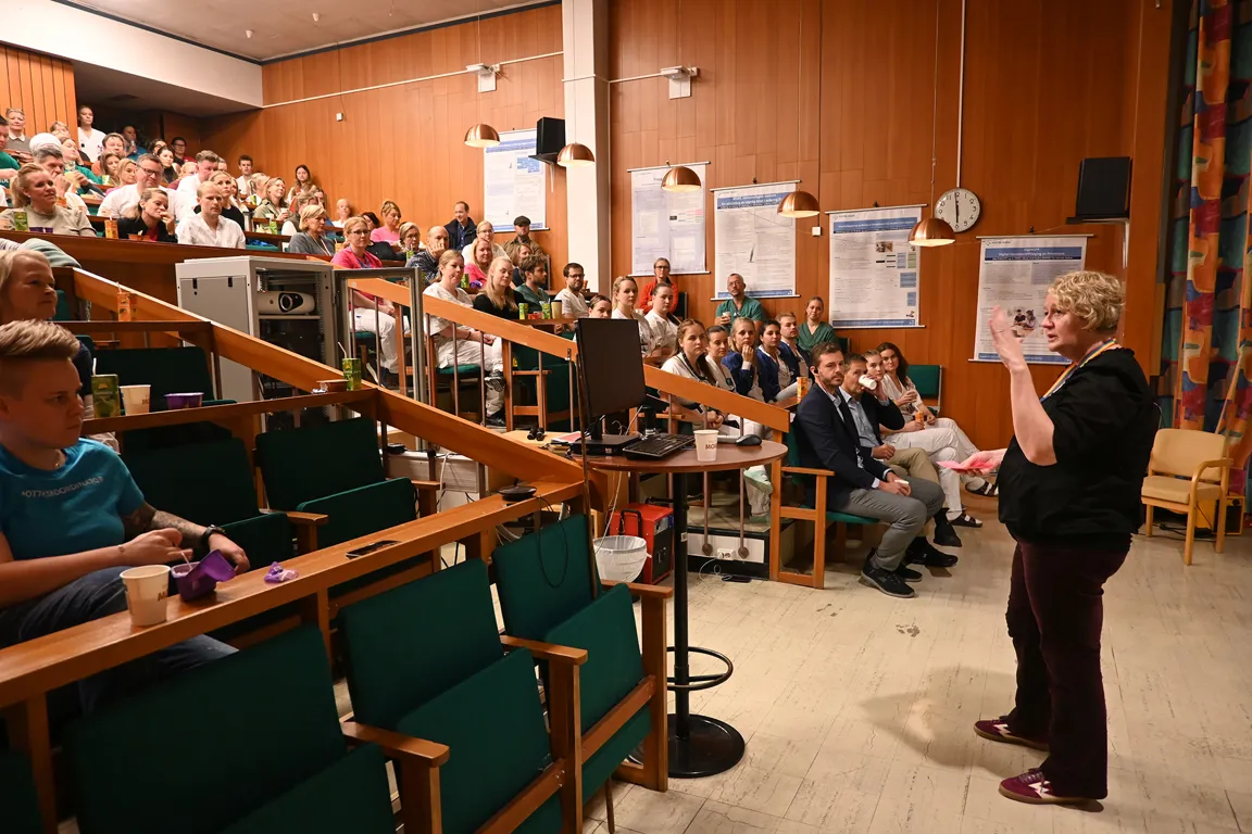 En person som holder en presentasjon for en gruppe personer i et rom