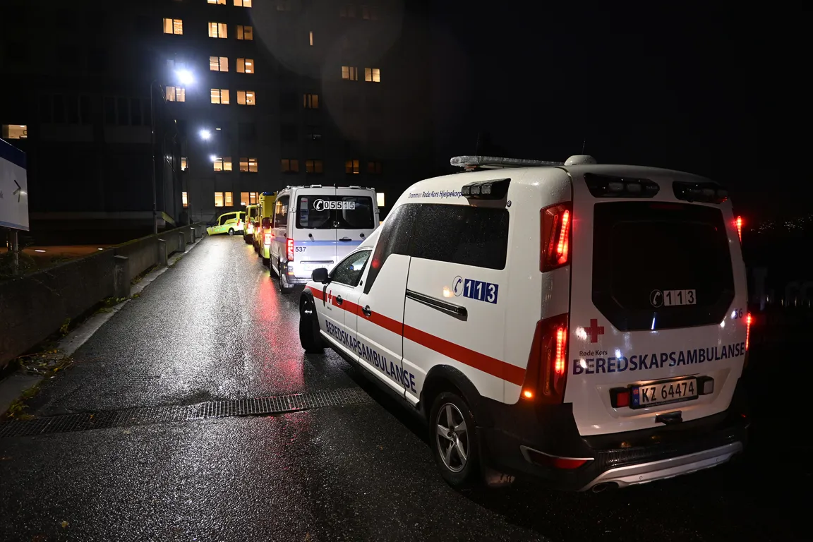 En gruppe hvite varebiler på en gate om natten