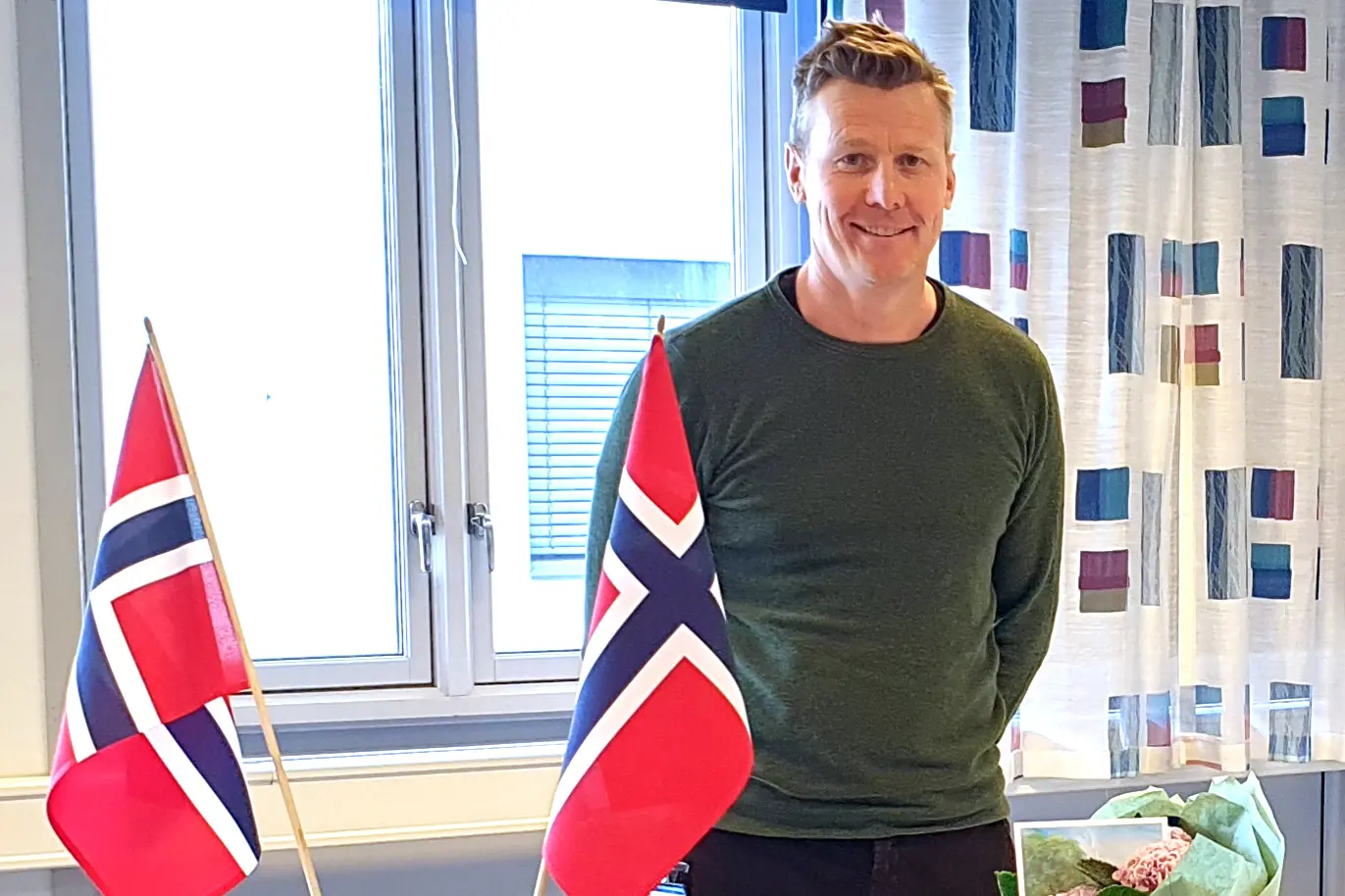 En person som står foran et vindu med et flagg