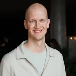 En mann som smiler til kameraet