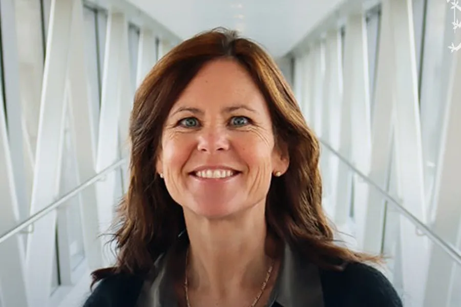 En kvinne som smiler til kameraet