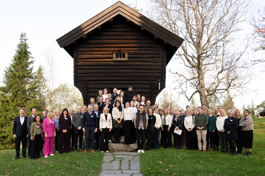 En gruppe mennesker som poserer for et bilde foran en bygning