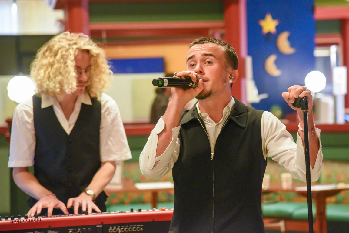 En mann og kvinne som synger i mikrofoner