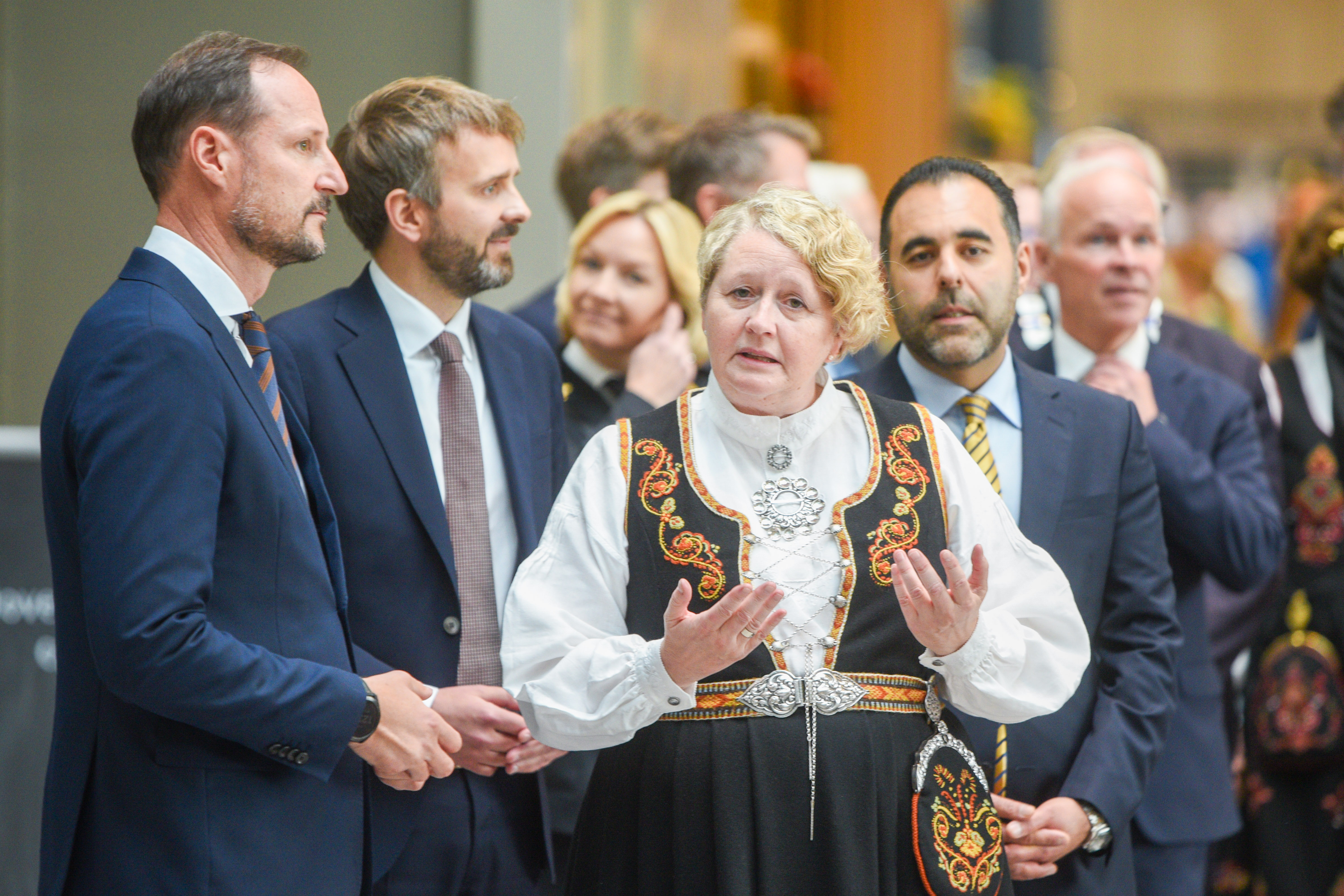 En mann i en kappe med en mengde mennesker rundt seg