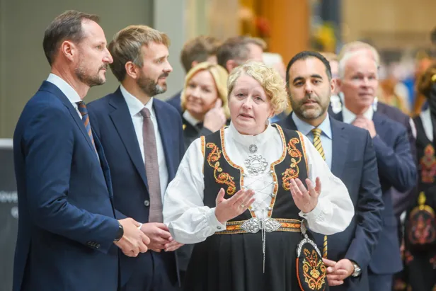 En mann i en kappe med en mengde mennesker rundt seg