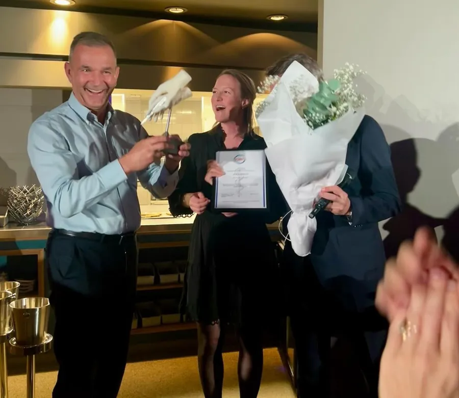 En mann og en kvinne som holder et stykke papir og en mann som holder et papir
