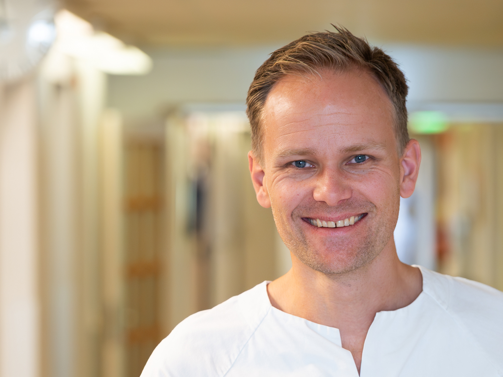 En mann som smiler til kameraet