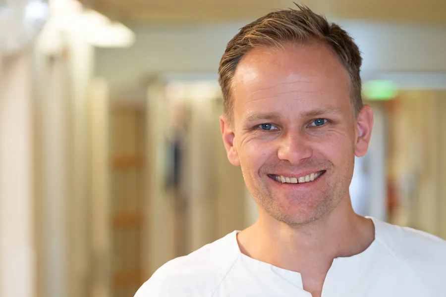 En mann som smiler til kameraet