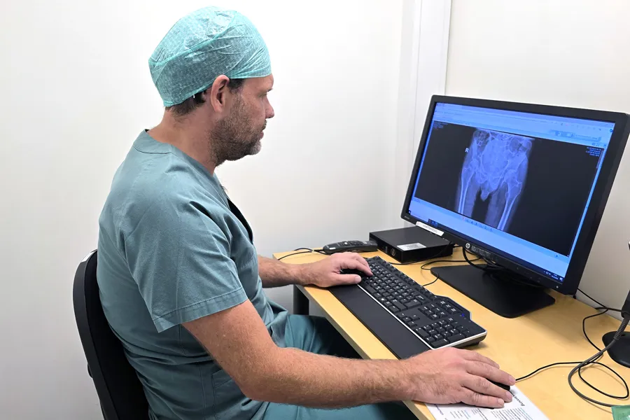 En mann som sitter ved et skrivebord med en datamaskin