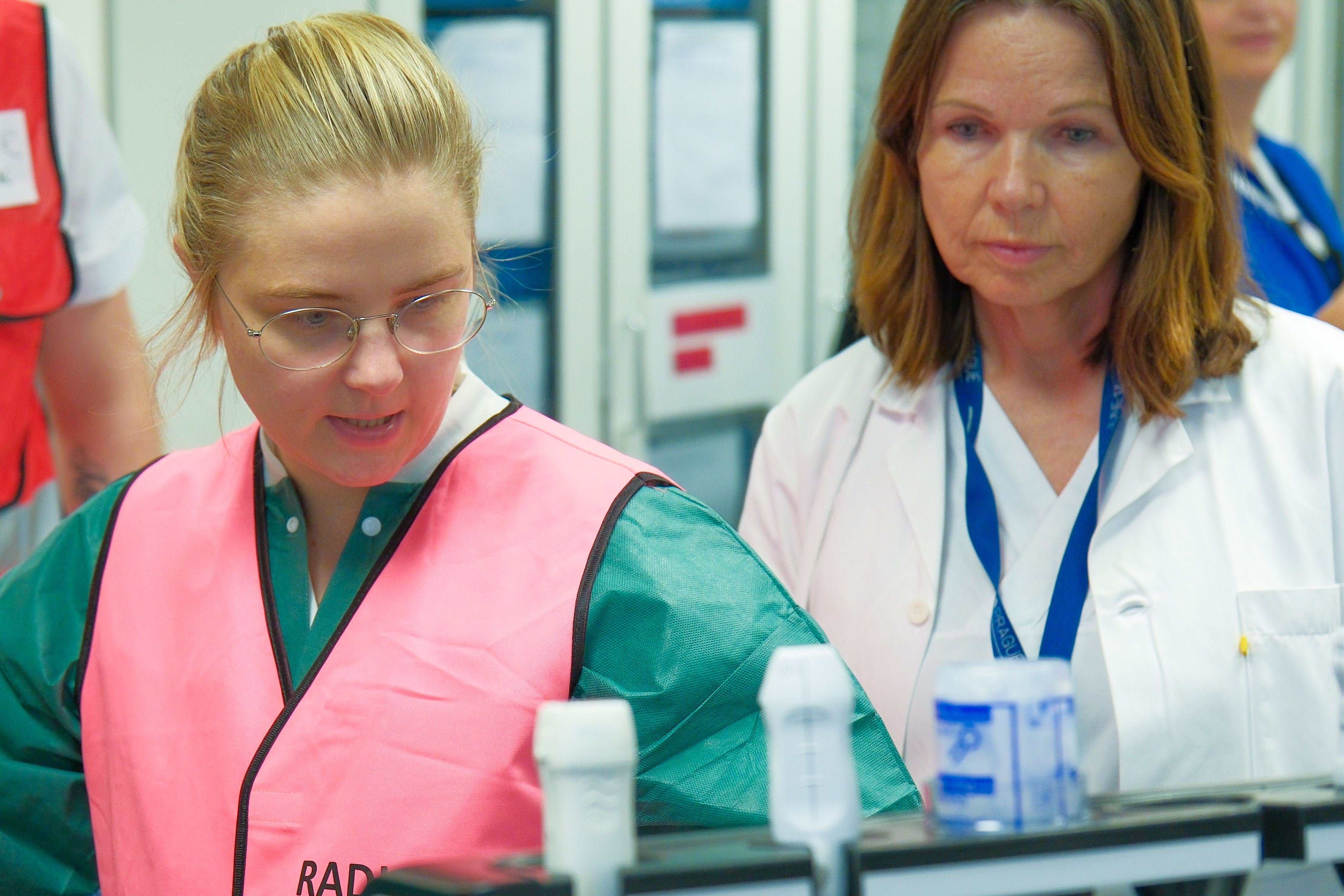 Kvinner i laboratoriefrakker som ser på reagensrør