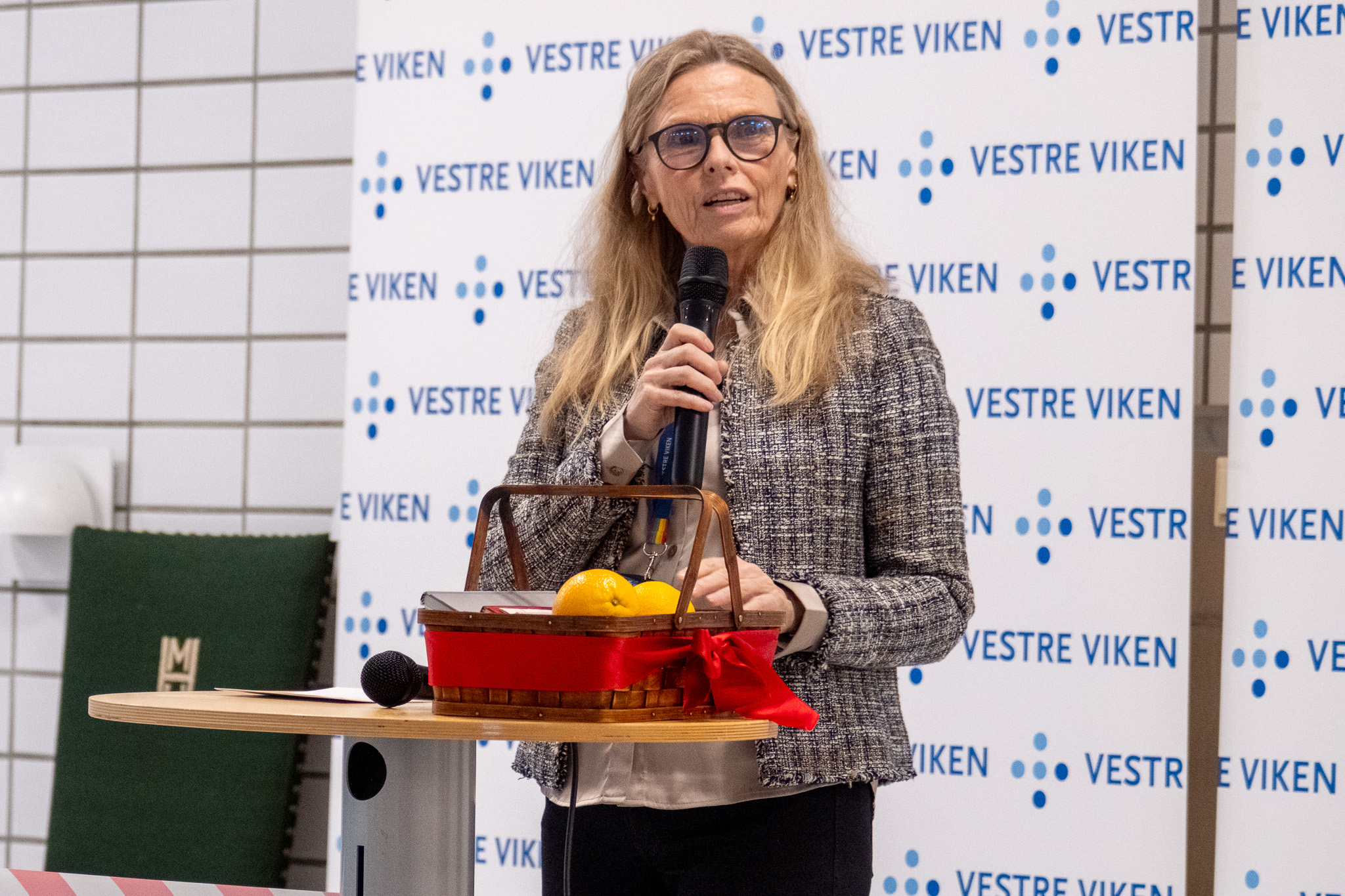 En person som holder en mikrofon og en kake