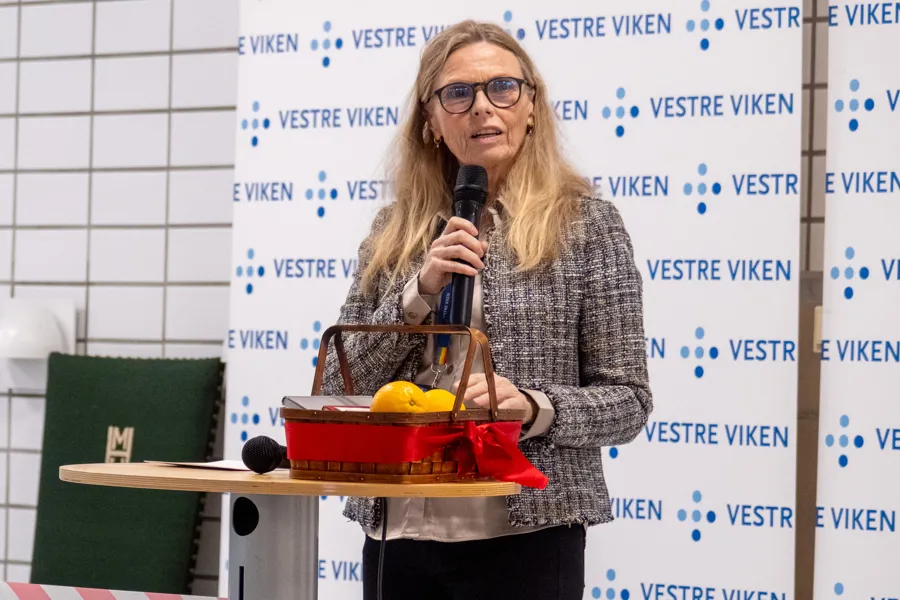 En person som holder en mikrofon og en kake