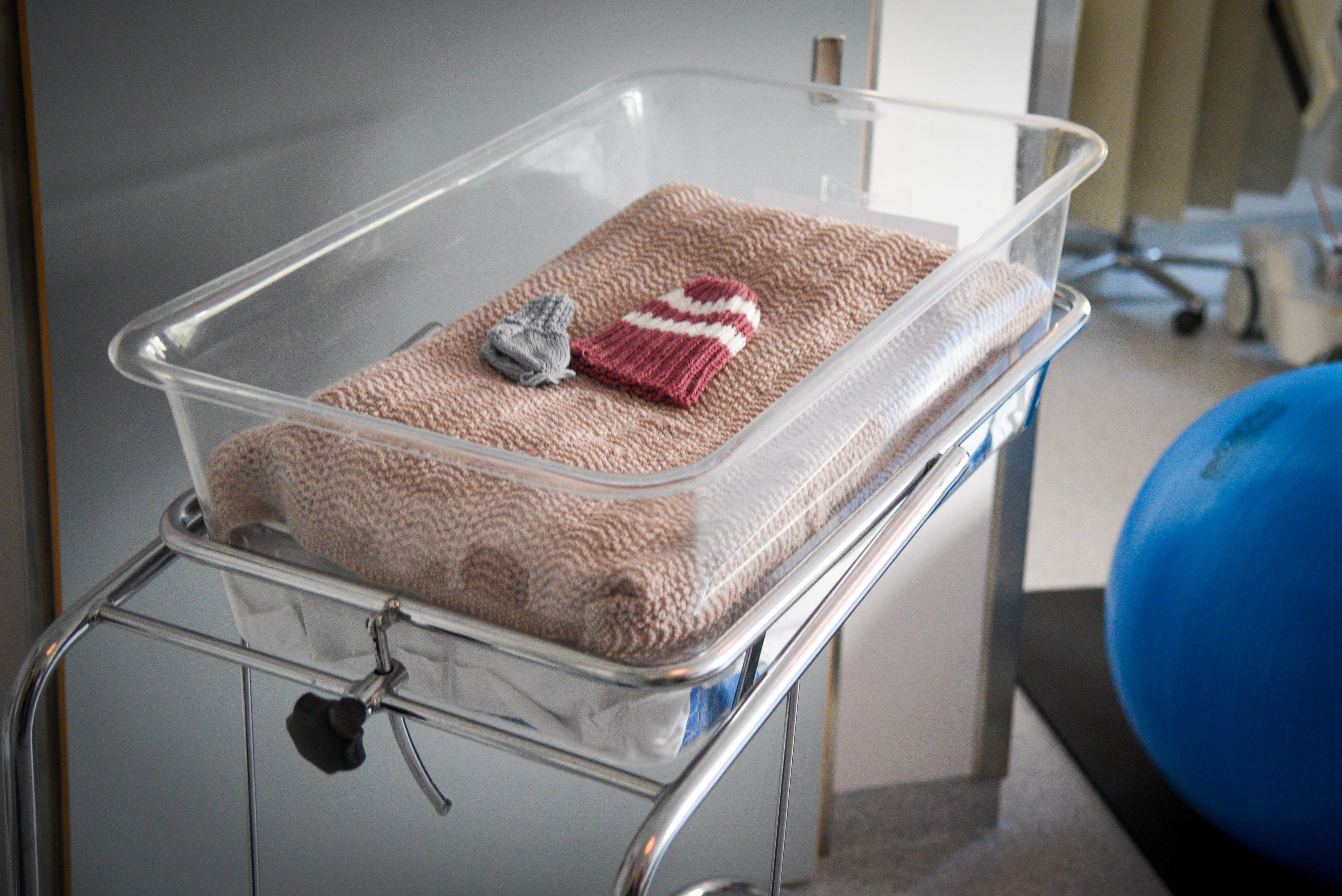 En hvit seng med en rød hjertepute og en blå ball