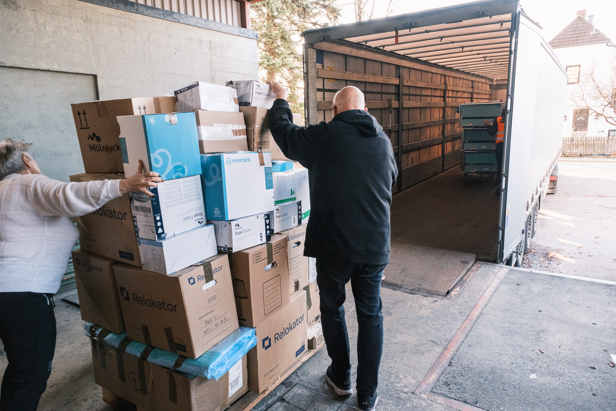 En mann som står ved siden av en stabel med esker