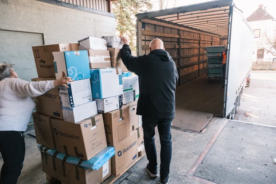 En mann som står ved siden av en stabel med esker