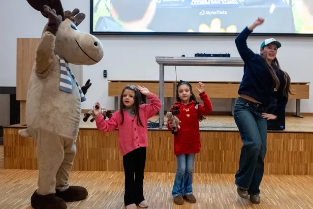 En gruppe mennesker som poserer med en person i et plagg