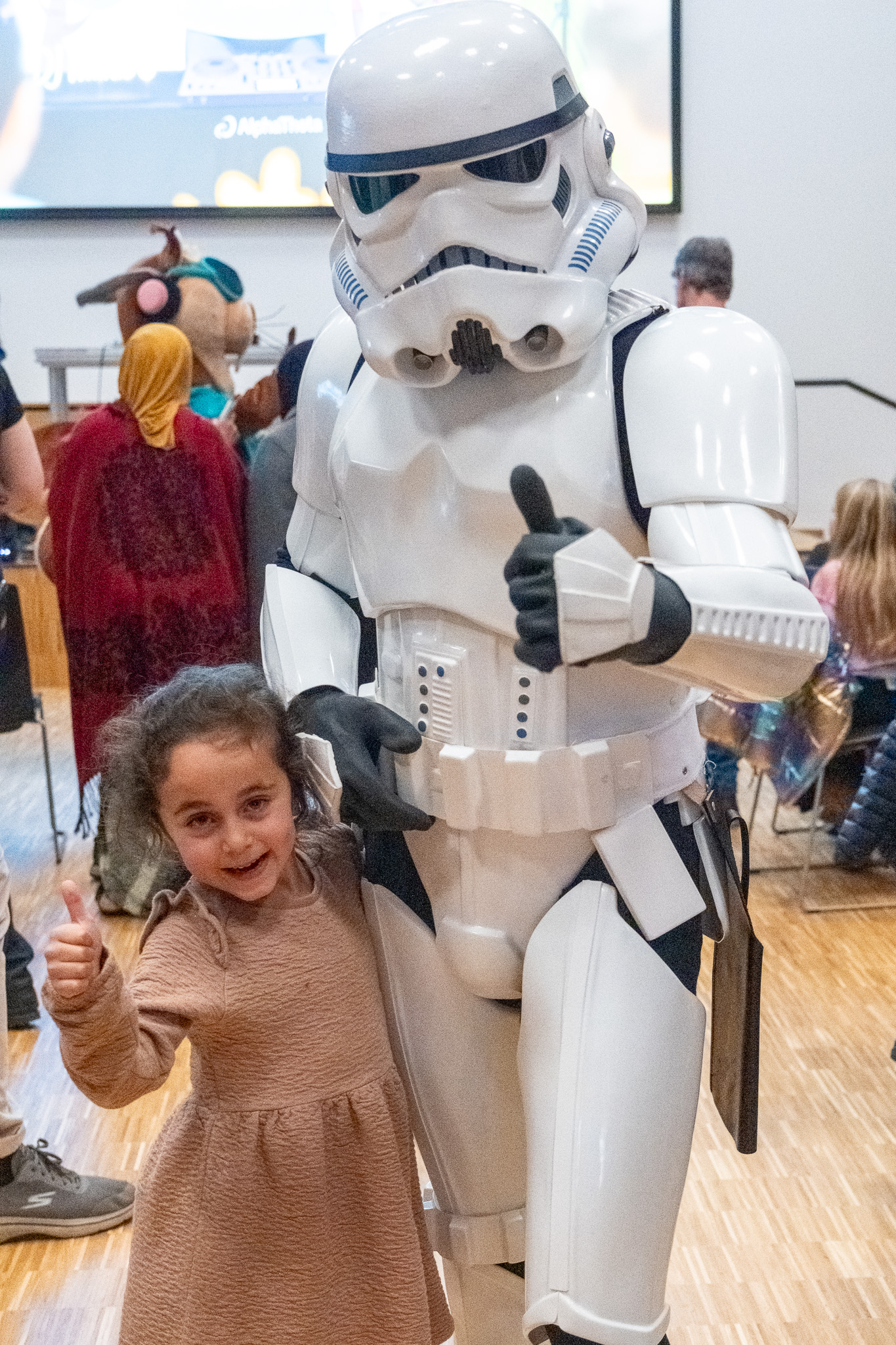 En jente som står ved siden av en person i et plagg