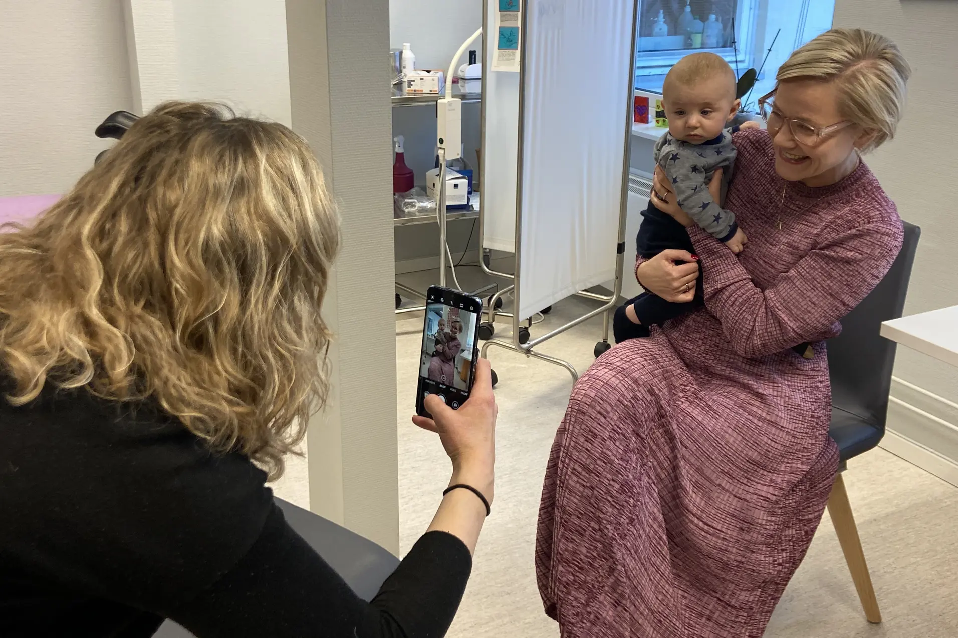 En kvinne som holder en baby