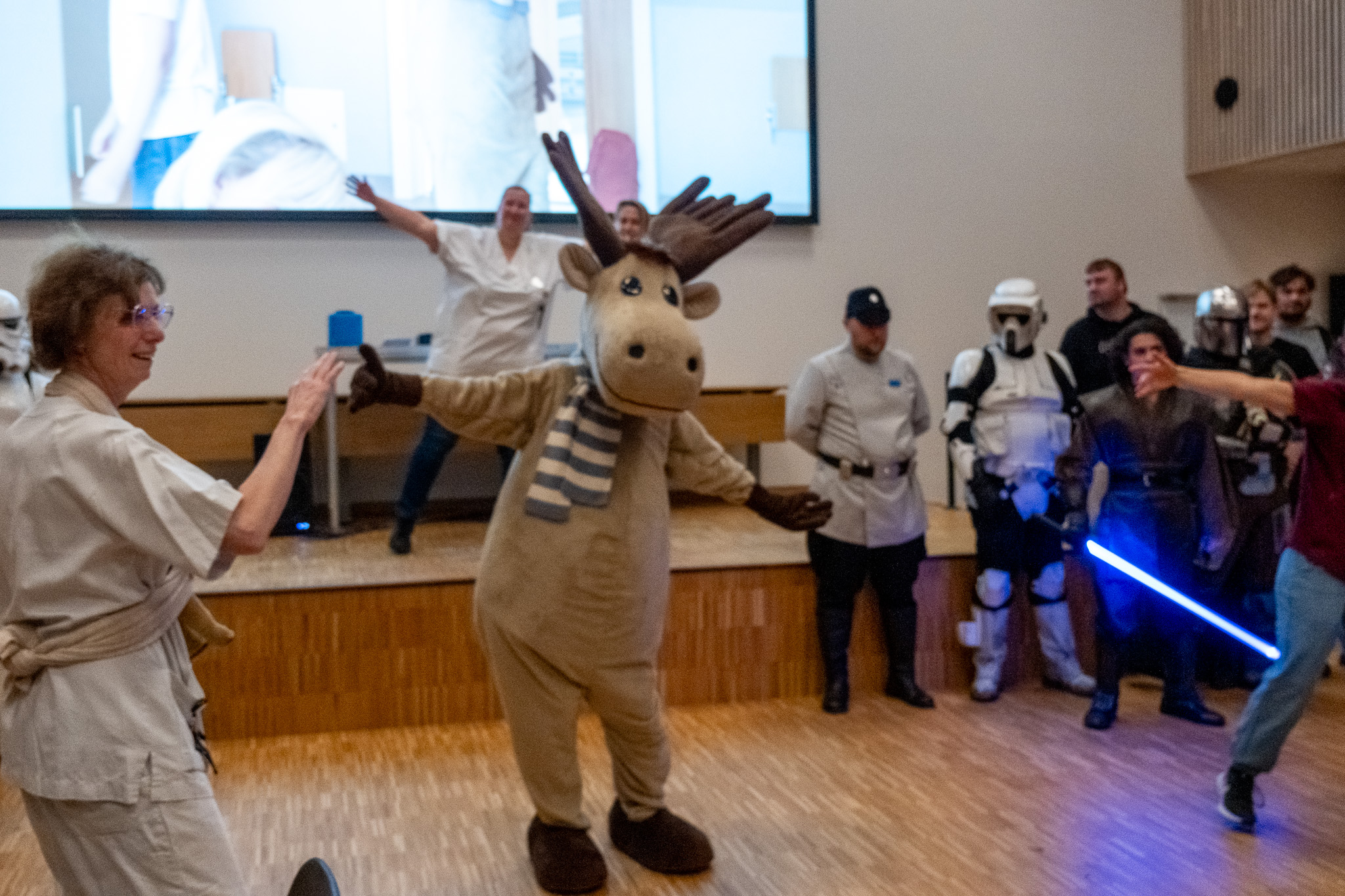 En person i et plagg med et sverd og en gruppe mennesker